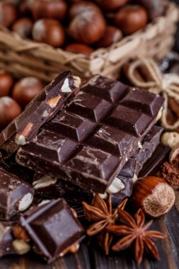 Tahta bir masa üzerinde nane yaprağıyla dilimlenmiş çikolata yığını. Beyaz, siyah ve sütlü çikolata çeşitleri. Tatlı yemek fotoğraf konsepti.