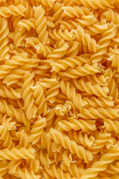 ドライパスタ フュージリ フシリは螺旋状と黄色をしています パスタは麺のような小麦粉で作られたおいしいイタリアの伝統的な食品です パスタの背景 — ストック写真