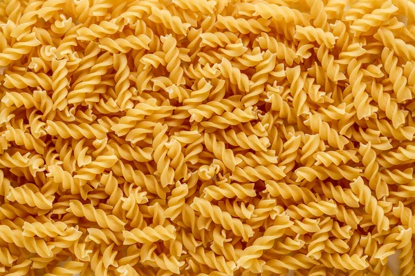 ドライパスタ フュージリ フシリは螺旋状と黄色をしています パスタは麺のような小麦粉で作られたおいしいイタリアの伝統的な食品です パスタの背景 — ストック写真