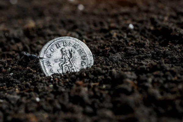 Ancient coin of the Roman Empire.Authentic silver denarius, antoninianus of ancient Rome.Roman silver coins covered in dirt.Antikvariat.