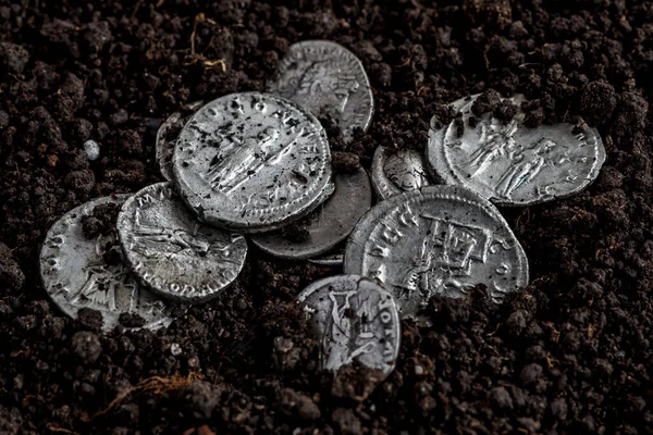 Ancient coin of the Roman Empire.Authentic silver denarius, antoninianus of ancient Rome.Roman silver coins covered in dirt.Antikvariat.