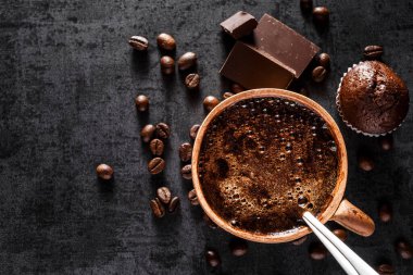 Siyah taş bir bardakta taze demlenmiş espresso. Kavrulmuş arabika ve robusta kahve çekirdekleri. Kahve çekirdekleri duvar kâğıdı. Üst manzara..