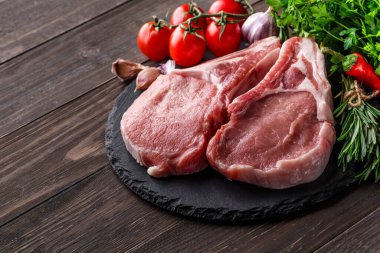 Çiğ et eti, kiraz domatesli, acı biber, sarımsak, yağ ve otlar koyu taşta, beton zeminde. Güzel manzara. Rustik tarzı..