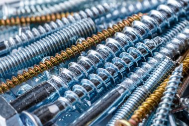 Çivi ve vida karışımı. Endüstriyel geçmiş. Ev yapımı. Sürgüler ve fındıklar. Çeşitli vidalara yakın çekim. Arkaplan ve üst görünüm için kullan.