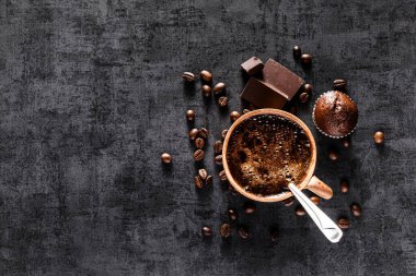 Siyah taş bir bardakta taze demlenmiş espresso. Kavrulmuş arabika ve robusta kahve çekirdekleri. Kahve çekirdekleri duvar kâğıdı. Üst manzara..