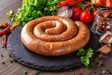 Spiral barbekü sosisleri, ızgara sosisler, ev yapımı, tavada, beton gri bir taş masada, üst manzara. Brezilya barbeküsü. Boşluğu kopyala