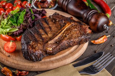 Beef T-Bone steak, herbs and spices on a dark table. Top view. Free space for your text. clipart
