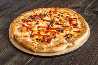 Domates soslu taze pizza, siyah zeytin, mozzarella peyniri, ahşap masadaki jambon. Metin veya kopyalama alanı için boşluk. Pizza menüsü. Restoran menüsü reklamı