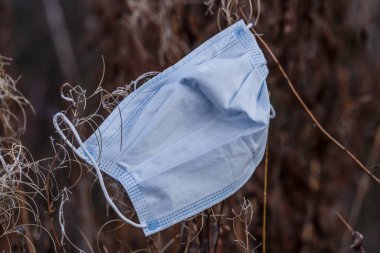 Coronavirus COVID-19 pandemic. Sokaktaki tıbbi yüz maskesi. Asfaltın üzerine rastgele saçılmış cerrahi maskeler. Asfaltta kayıp yüz maskesi