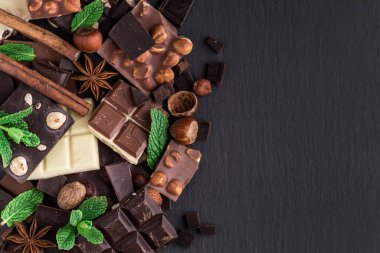 Beyaz, siyah ve sütlü çikolataların karışımı. Kırık çikolata parçaları. Tatlı yemek fotoğraf konsepti. Kopyalama alanı olan üst görünüm