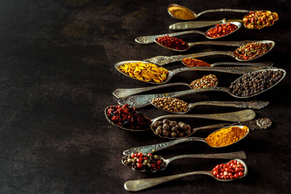 Various spices a vintage spoons on stone table. Colorful Herbal and Spices Oriental marketplace.Top view . Cafe concept. Delicious food delivery.