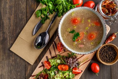 Koyu ahşap arka planda bir kasede tavuk filetosu ile sebze çorbası. Fotokopi alanı olan üst manzara. Tavuk çorbası pişiriyorum..