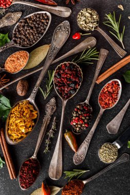 Değişik baharatlar, taş masada kaliteli kaşıklar. Renkli bitkisel ve baharatlı doğu pazarı. Manzara harika. Kafe konsepti. Lezzetli yemek servisi..