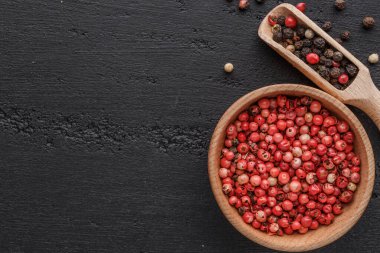 Bir biber seti. Farklı tip biber kolajı, siyah, beyaz, pembe ve tüm baharatlı biber, kurutulmuş kırmızı biber. Üst görünüm. Siyah bir arka planda. Metnin için boş yer.