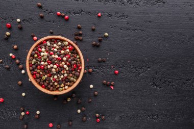 Bir biber seti. Farklı tip biber kolajı, siyah, beyaz, pembe ve tüm baharatlı biber, kurutulmuş kırmızı biber. Üst görünüm. Siyah bir arka planda. Metnin için boş yer.