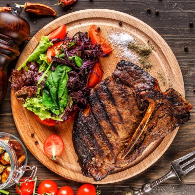 Biftek, şifalı otlar ve baharatlar karanlık bir masada. Üst Manzara. Metnin için boş yer.