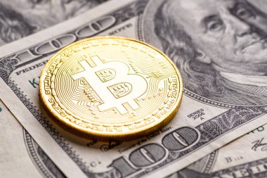 Altın Bitcoin banknotların üzerinde yatıyor. Yeni sanal para. Şifreli para birimi üst görünümü. 100 dolarlık banknotlarda gerçek bitcoin paraları. Değiş tokuş, reklam. çevrimiçi iş kavramı.