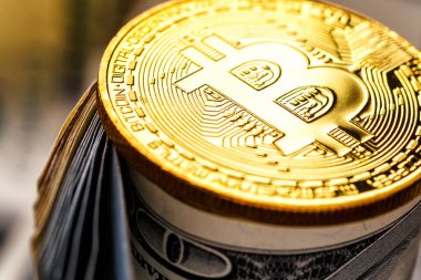 Altın Bitcoin banknotların üzerinde yatıyor. Yeni sanal para. Şifreli para birimi üst görünümü. 100 dolarlık banknotlarda gerçek bitcoin paraları. Değiş tokuş, reklam. çevrimiçi iş kavramı.