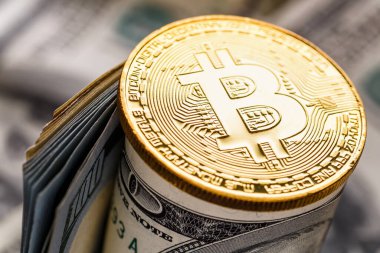 Altın Bitcoin banknotların üzerinde yatıyor. Yeni sanal para. Şifreli para birimi üst görünümü. 100 dolarlık banknotlarda gerçek bitcoin paraları. Değiş tokuş, reklam. çevrimiçi iş kavramı.