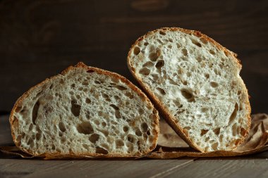 Ekmek, kırsal ahşap arka planda dilimlenmiş geleneksel ekşi ekmek. Geleneksel mayalanmış ekmek pişirme yöntemleri kavramı. Sağlıklı yemek..