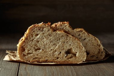 Ekmek, kırsal ahşap arka planda dilimlenmiş geleneksel ekşi ekmek. Geleneksel mayalanmış ekmek pişirme yöntemleri kavramı. Sağlıklı yemek..