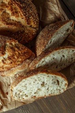 Ekmek, kırsal ahşap arka planda dilimlenmiş geleneksel ekşi ekmek. Geleneksel mayalanmış ekmek pişirme yöntemleri kavramı. Sağlıklı yemek..