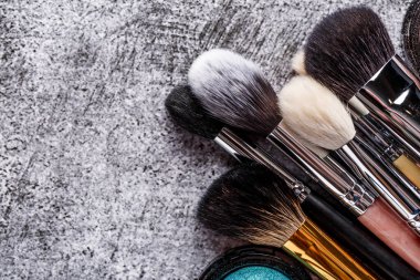 Profesyonel makyaj fırçaları ve aletleri, makyaj ürünü seti. Gri arka planda dekoratif kozmetik seti. Düz yatış, üst görünüm.