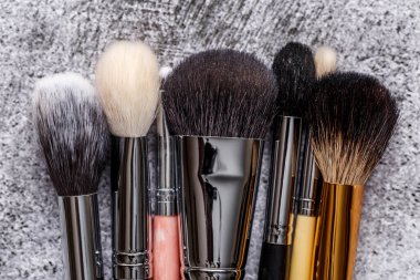 Profesyonel makyaj fırçaları ve aletleri, makyaj ürünü seti. Gri arka planda dekoratif kozmetik seti. Düz yatış, üst görünüm.