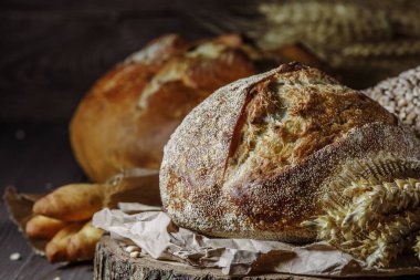 Ekmek, kırsal ahşap arka planda dilimlenmiş geleneksel ekşi ekmek. Geleneksel mayalanmış ekmek pişirme yöntemleri kavramı. Sağlıklı yemek..