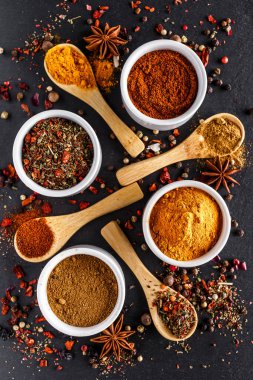 Değişik baharatlar, taş masada kaliteli kaşıklar. Renkli bitkisel ve baharatlı doğu pazarı. Manzara harika. Kafe konsepti. Lezzetli yemek servisi..