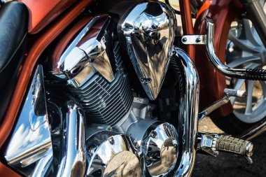 Atölyedeki modern bir motosikletin ayrıntıları. Motosiklet egzozu. Seçici odaklanma. Kapatılmış ve seçilmiş büyük motosiklet motoru ve diğer detaylar.