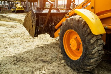 Buldozer yol kenarındaki toprak ve moloz yığınını hareket ettiriyor. İnşaat alanındaki toprak üzerinde çalışan buldozer. Yol yapım aşamasında..