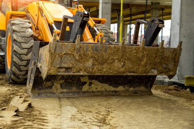 Buldozer yol kenarındaki toprak ve moloz yığınını hareket ettiriyor. İnşaat alanındaki toprak üzerinde çalışan buldozer. Yol yapım aşamasında..