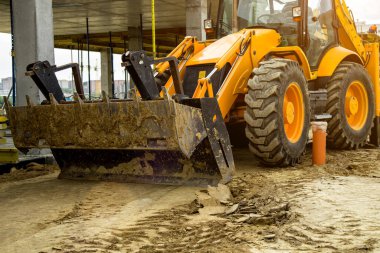 Buldozer yol kenarındaki toprak ve moloz yığınını hareket ettiriyor. İnşaat alanındaki toprak üzerinde çalışan buldozer. Yol yapım aşamasında..