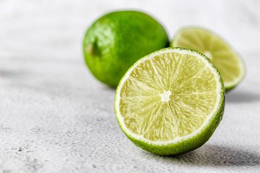 İkiye bölünmüş yeşil kireç ve beyaz arka planda izole edilmiş dilimler. Sağlıklı yeşil gıdalar - alternatif tıp vitaminler, besinler ve insan refahı için süper yiyecekler içeren dengeli bir diyet içerir..