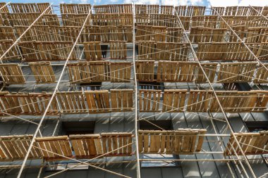 Yeni bir apartman bloğunda çalışma platformları sağlayan kapsamlı yapı iskeleleri, inşaat halindeki uzun binalar, Yeni Bina İnşaat Alanı