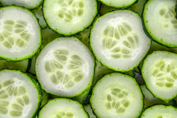 a background of chopped fresh cucumbers for the kitchen.Cucumbers background.Cucumbers for salads or canning. Summer vegetables.