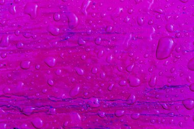 Yağmurdan sonra mor boyalı ahşap bir yüzey üzerindeki su damlacıklarının soyut deseni. Üst Manzara. Tasarım için soyut arkaplan ve doku.