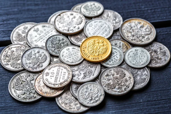 Gold and silver coins of the Russian Empire19 - 20 century in the background kopyur.Five rubles Nicholas II.Concept Russian antiques.Antikvariat.