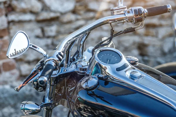 The chromed handlebar of a motorcycle.Travel and freedom, outdoor activities. View of motorcycle handlebar in the background many motorbikes blurred, concept of speed and travel in nature