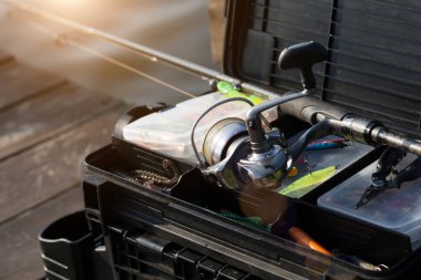 Balık tutmak için yem ve ekipman dolu büyük bir balıkçı çantası. Arka planda balık yemi ve aksesuarları var..