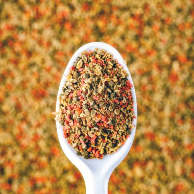 Akvaryum balığı için kuru gıda kaşık bileşikli balık pulları. Tropikal akvaryum balığını beslemek için gevrek ve granül yığını. 