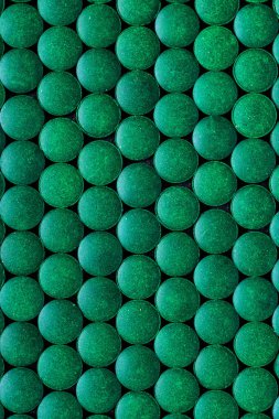 Akvaryum balığı yemi kapanışı. Tropikal akvaryum balığını beslemek için granül spirulinası, Top View. Koyu yeşil yuvarlak sarmal akvaryum tabletleri.