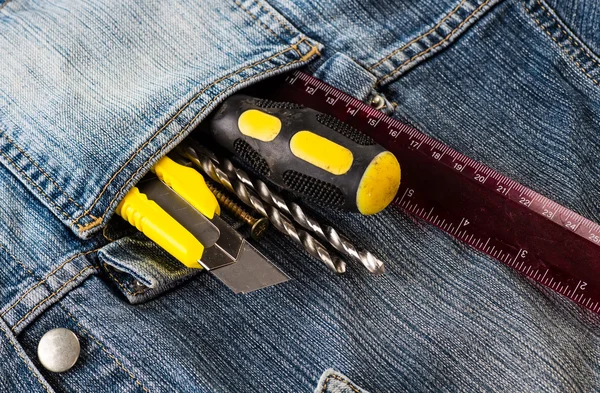 Ferramentas, chave de fenda, parafuso, faca estacionária em jaqueta jeans azul — Fotografia de Stock