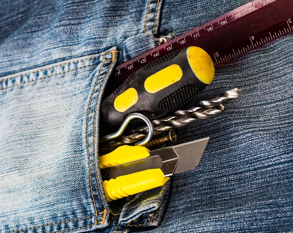 Ferramentas, chave de fenda, parafuso, faca estacionária em jaqueta jeans azul — Fotografia de Stock