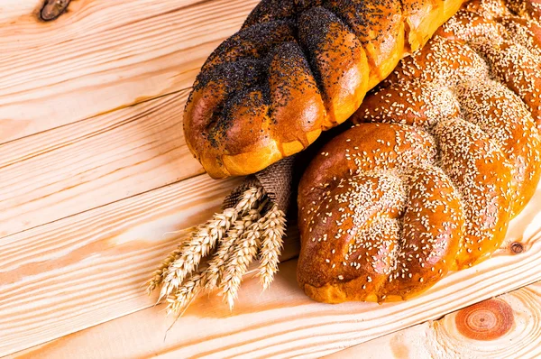Haşhaş ve bir tahta üzerinde susam ile iki bütün taze challah ekmek