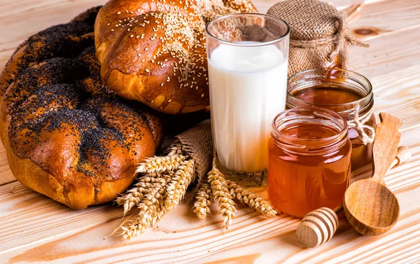Смачні булочки з маком та кунжутом молоко та мед на дерев'яному фоні — стокове фото