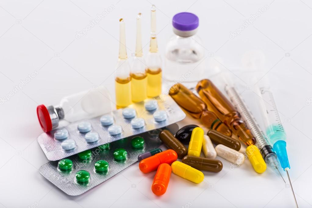 Medications tablets and capsules in a beaker