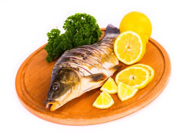 Balık ile limon, maydanoz mutfak tahta üzerinde beyaz bir arka plan üzerinde 