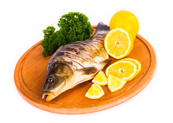 Balık ile limon, maydanoz mutfak tahta üzerinde beyaz bir arka plan üzerinde 